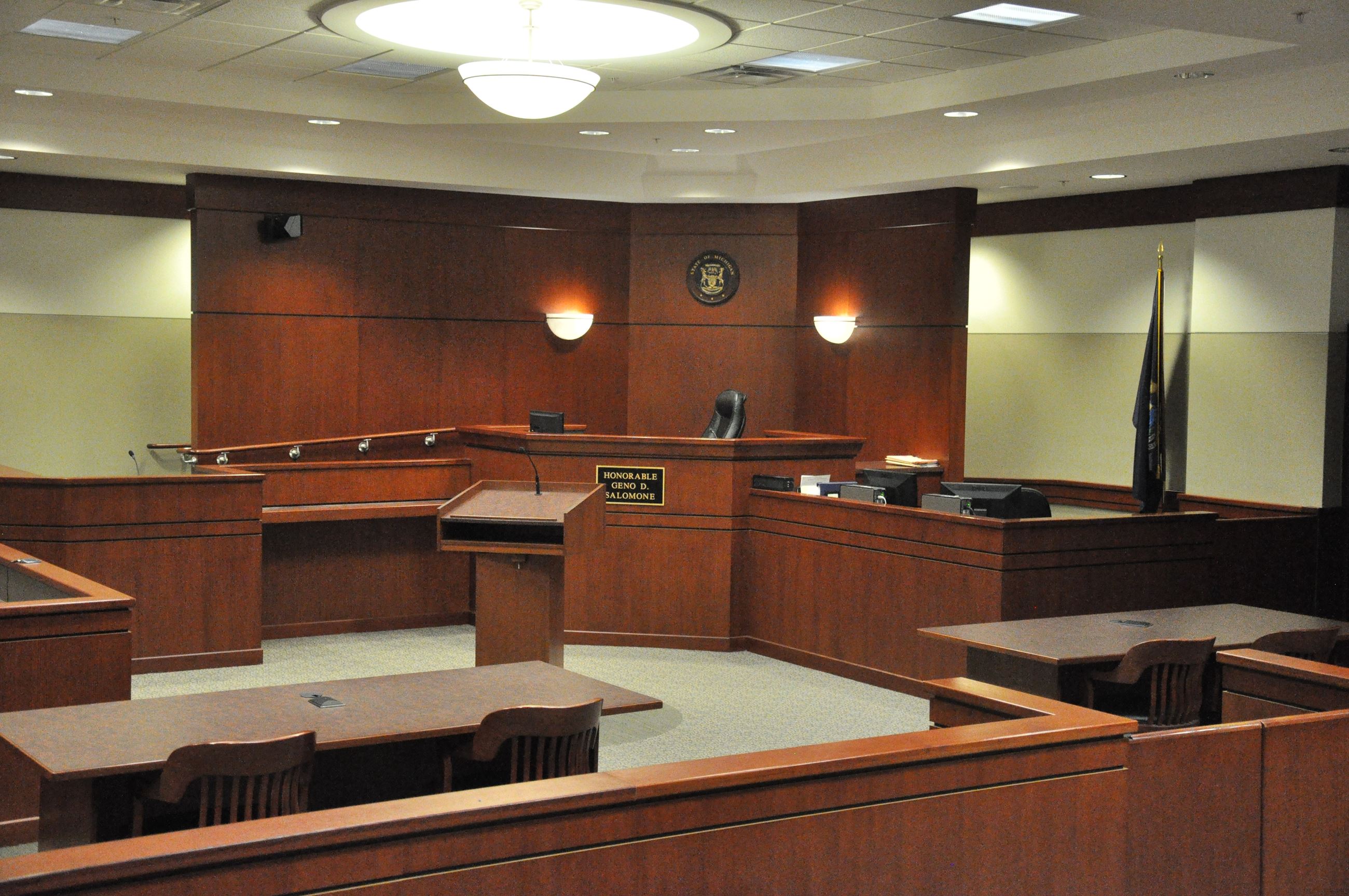 Empty courtroom with wooden benches.
