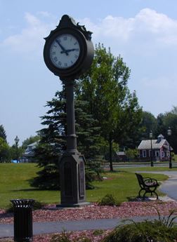 A large clock standing in a park.