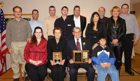 A group of people standing with a Sam Terry holding a plaque.