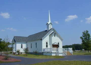 A white church under a blue sky.